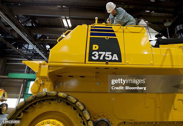 An employee makes a final inspection for a Komatsu Ltd. D375A mining dozer on the production line of the company's plant in Hirakata City, Osaka,...