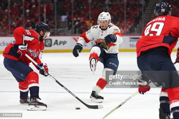 Gustav Forsling of the Florida Panthers kicks the puck to keep it in the zone in front of Marcus Johansson of the Washington Capitals during the...