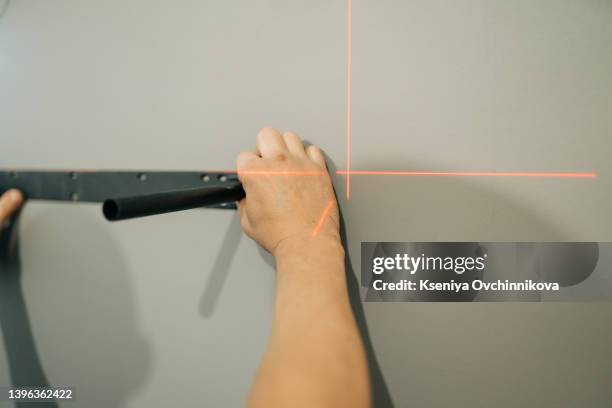 man measuring with tape with red laser level on wooden wall - laser ruler stock pictures, royalty-free photos & images
