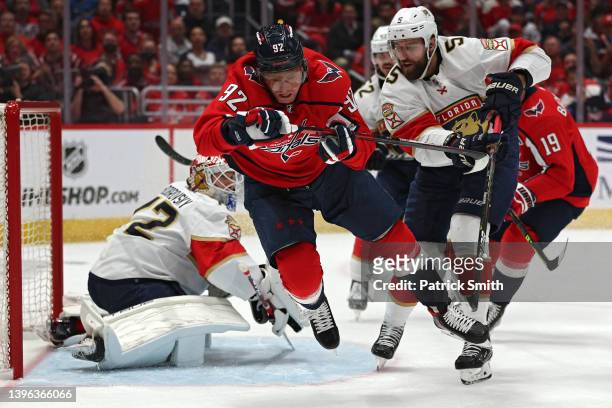 Evgeny Kuznetsov of the Washington Capitals is tripped by Aaron Ekblad of the Florida Panthers during the second period in Game Four of the First...