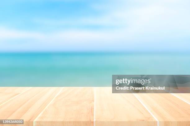 top of the wood table in front of the white beach background - coconut white background stock-fotos und bilder