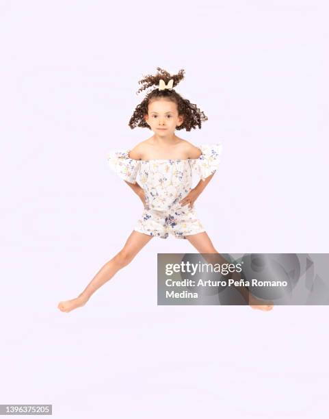 girl jumping with her hands on her hips - tiny mexican girl stock pictures, royalty-free photos & images