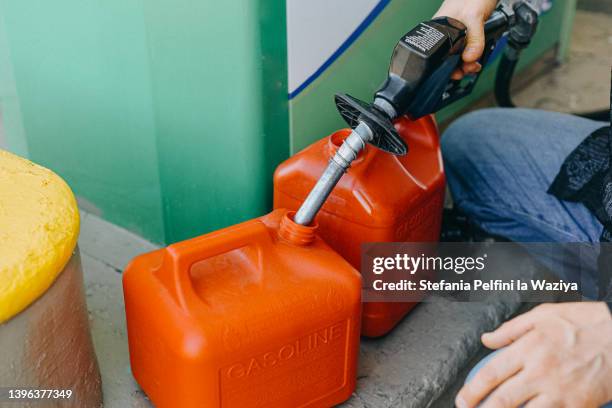 man filling up gas cans at gas station - récipient sous pression photos et images de collection