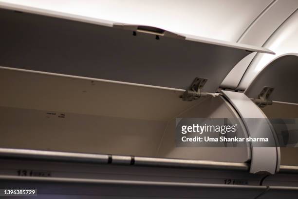 empty luggage cabin inside a flight. - luggage rack stock-fotos und bilder