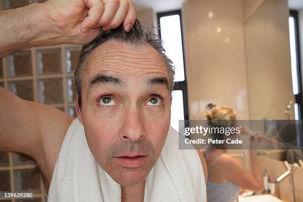 bathroom, man looking into camera/mirror - balding stock-fotos und bilder