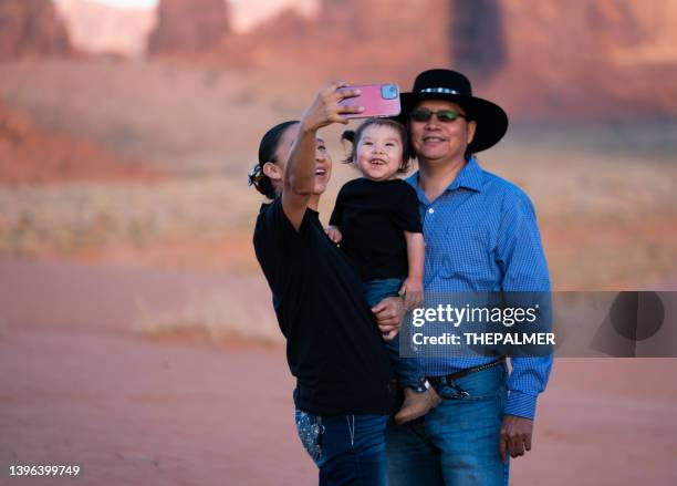 family with small kid taking a selfie with smart phone - native american reservation stockfoto's en -beelden