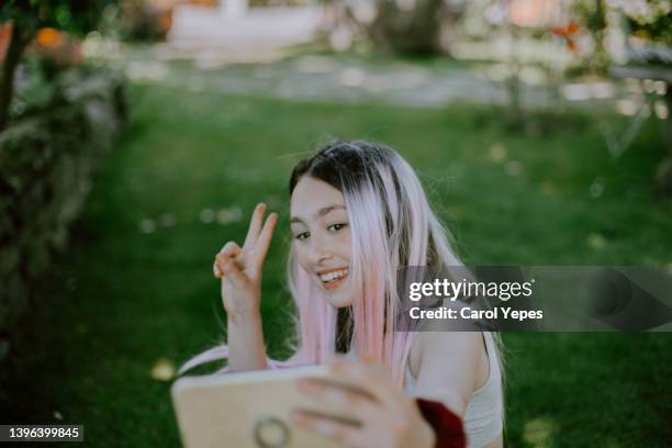 girl using  cell phone to take a selfie sticking out tongue - friends laughing at iphone video stock pictures, royalty-free photos & images