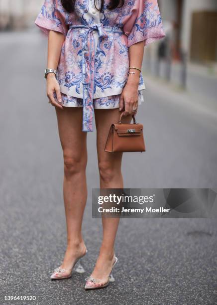 Leo Eberlin wearing transparent Amina Muaddi heels, Zimmermann two piece silk set with print, mini Hermes brown leather Kelly bag on May 06, 2022 in...