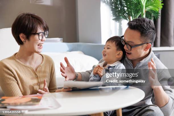 young parents tell stories to their son - 2 year old book stock pictures, royalty-free photos & images