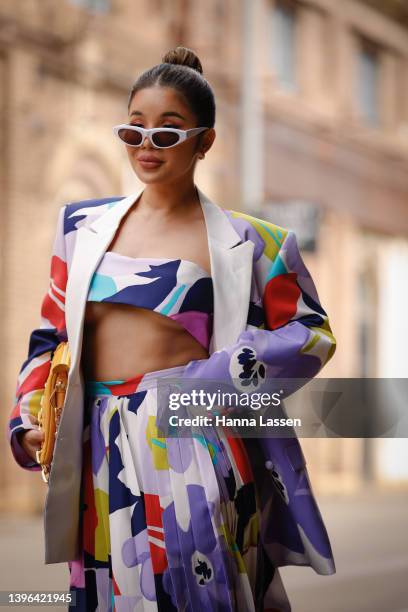 Piyane Ung wearing Cambodian designer Kong LABEL and Louis Vuitton yellow clutch at Afterpay Australian Fashion Week 2022 on May 10, 2022 in Sydney,...