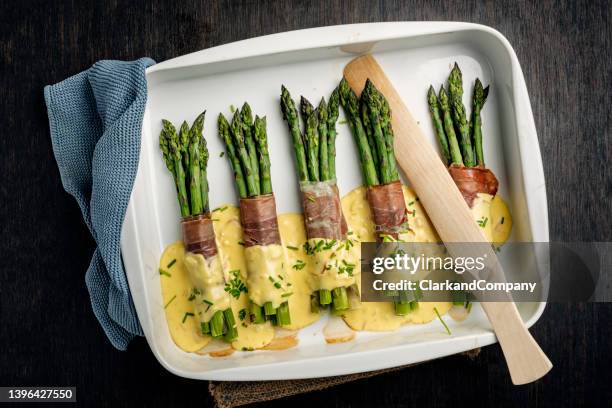 asparagus wrapped with parma ham and hollandaise sauce. - asperge stockfoto's en -beelden