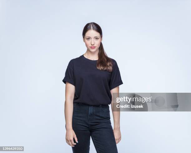 selbstbewusste frau vor weißem hintergrund - t shirt stock-fotos und bilder