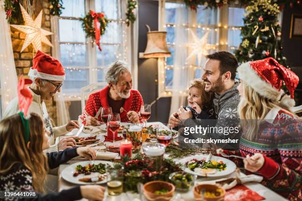 happy extended family having new year's lunch at dining table. - large group of people eating stock pictures, royalty-free photos & images