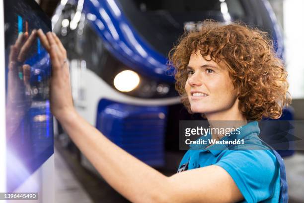 smiling engineer using touch screen device in factory - rail worker stock pictures, royalty-free photos & images