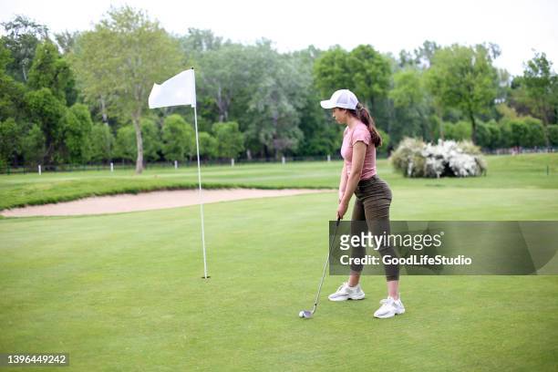 mujer joven jugando al golf - golf clubhouse fotografías e imágenes de stock