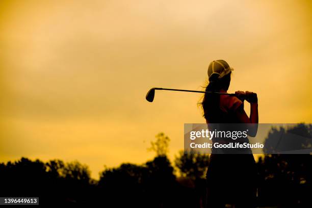 silhouette of a female golf player - golf swing sunset stock pictures, royalty-free photos & images