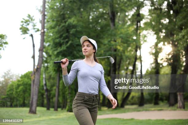 young woman playing golf - country club woman stock pictures, royalty-free photos & images