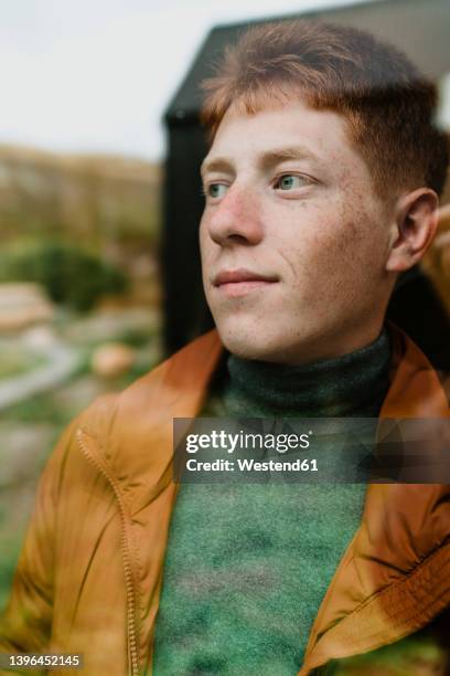 thoughtful teenage boy seen through glass - redhead teen fotografías e imágenes de stock