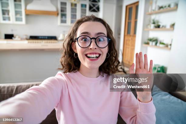 happy woman taking selfie at home - zwaaien gebaren stockfoto's en -beelden