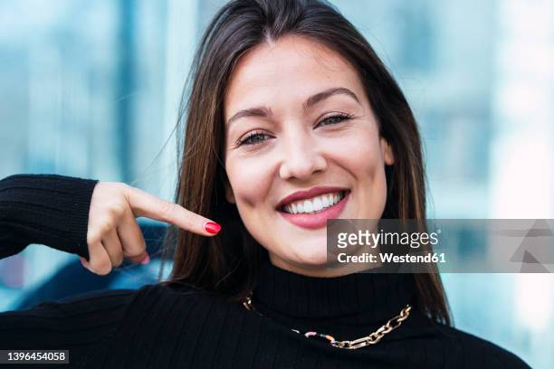 happy young woman gesturing with finger - fossetta foto e immagini stock