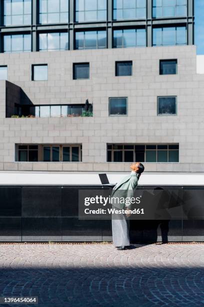 businesswoman bending backward by office building - dipping stock pictures, royalty-free photos & images