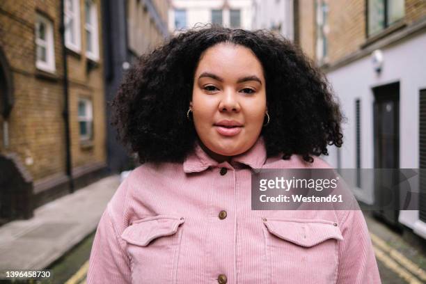 young woman with curly hair standing on road - mannequin grande taille photos et images de collection