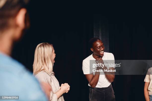 happy young male artist with stage performers practicing in class - faire du théâtre photos et images de collection
