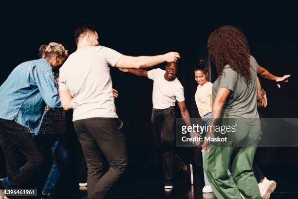 multiracial male and female stage performers dancing during rehearsal in class - asian actress stock pictures, royalty-free photos & images