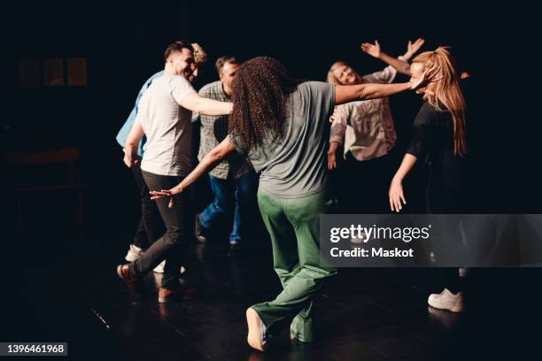 full length of multiracial male and female artists dancing together in class - faire du théâtre photos et images de collection