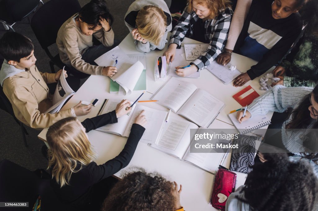 High angle view of pupils preparing for exam in classroom