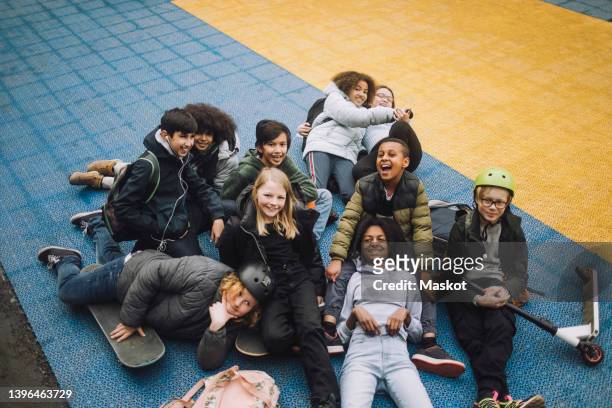 high angle view of diverse school students relaxing in sports court - groepsfoto 6 personen stockfoto's en -beelden