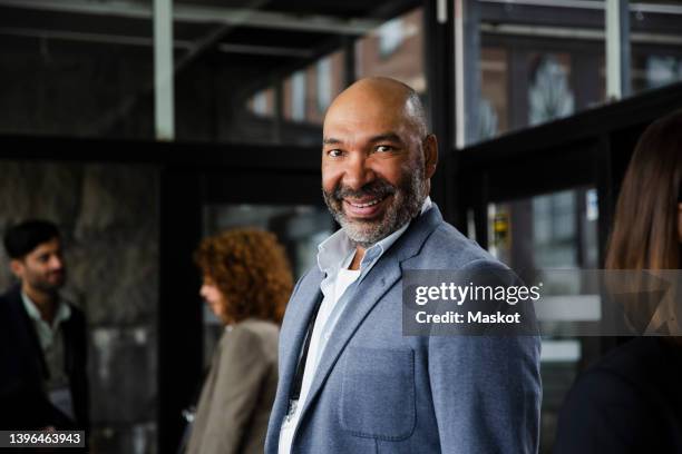 portrait of smiling businessman in blue blazer at seminar - 55 to 60 years old african american male stock pictures, royalty-free photos & images