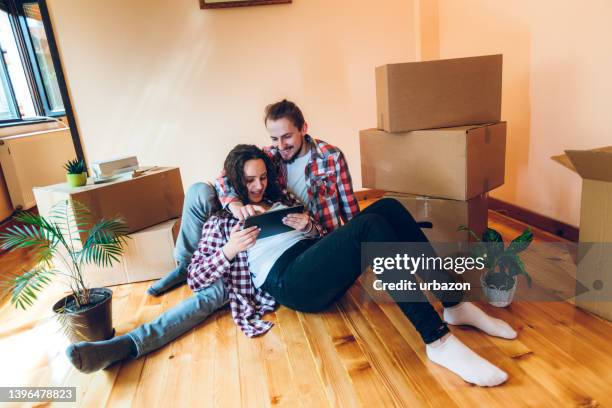 couple checking redecorating plans - couple seated apartment hipster imagens e fotografias de stock