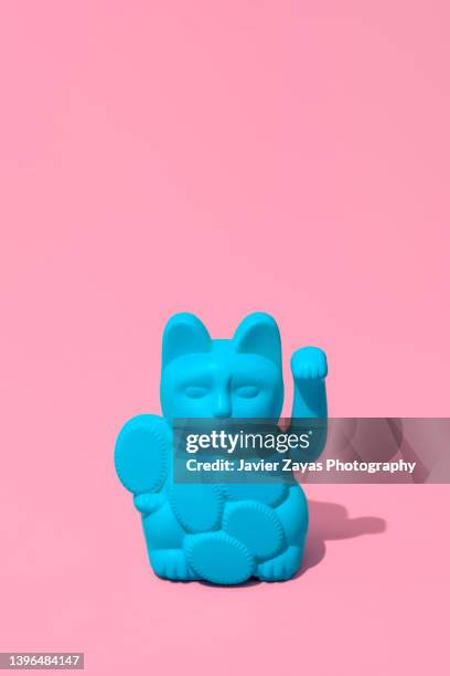 blue lucky cat (maneki neko) against pink background - maneki neko 個照片及圖片檔