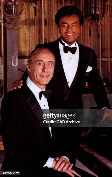 Circa 1975: Photo of songwriter and singer Johnny Mercer posed with singer Johnny Mathis circa 1975.