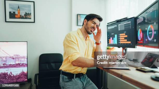 man with migraine working from home - stress test stockfoto's en -beelden