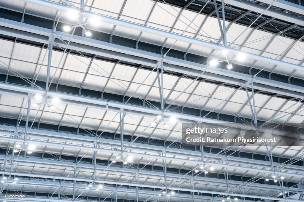 Ceiling with bright lights in a modern warehouse, shopping center building, office or other commercial real estate object. Directional LED lights on rails under the ceiling