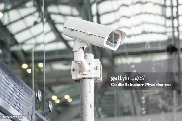 a security camera on the exterior of a building. - big brother stock pictures, royalty-free photos & images