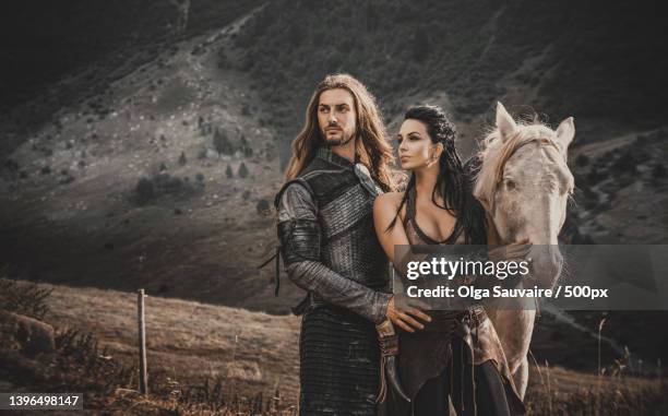 two young people with a horse standing in cosplay costumes in field,france - cosplay fotografías e imágenes de stock