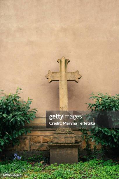 stone cross on the background of the wall. church. christianity. - funeral background stock pictures, royalty-free photos & images