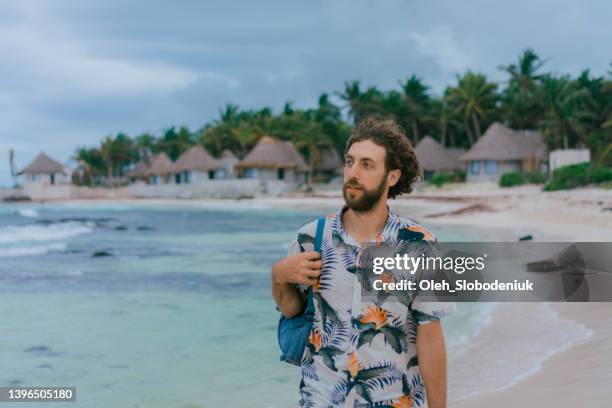 man with backpack walking on the beach in tulum - hawaiian shirt 個照片及圖片檔