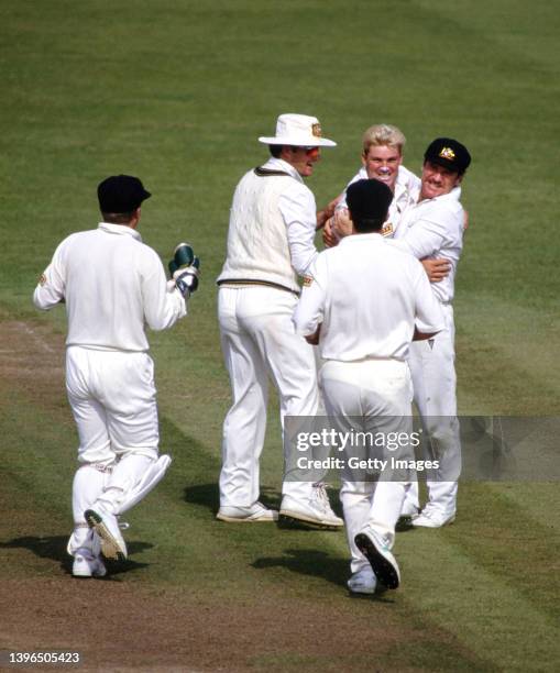 Australia leg spinner Shane Warne is congratulated by team mates including captain Allan Border and Mark Waugh after taking a wicket during the First...