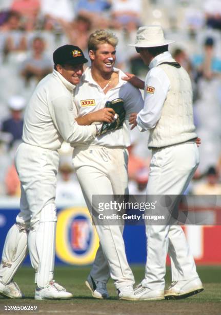 Australia leg spinner Shane Warne is congratulated by team mates Ian Healy and Mark Waugh after taking a wicket during the First Ashes Test Match...
