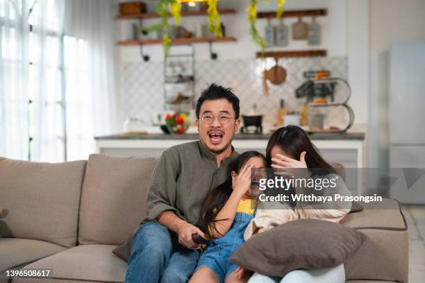 family watching scary halloween movie together on tv - asian cinema bildbanksfoton och bilder