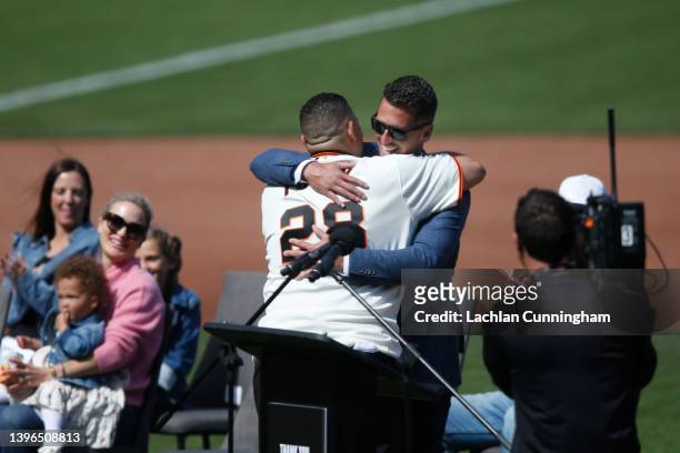 Former San Francisco Giants player Bengie Molina hugs Buster Posey during a ceremony for honoring Posey's retirement before the game between the San...