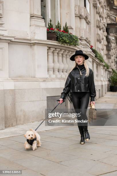 Lexi Fargo wears a Zara jacket, Intimissimi leggings, Hermes hat, Chanel earrings and boots, Valentino bag with Duke the dog wearing Prada during...