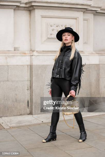 Lexi Fargo wears a Zara jacket, Intimissimi leggings, Hermes hat, Chanel earrings and boots, Valentino bag during London Fashion Week February 2022...