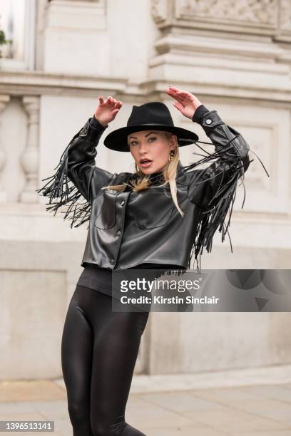 Lexi Fargo wears a Zara jacket, Intimissimi leggings, Hermes hat and Chanel earrings during London Fashion Week February 2022 on February 21, 2022 in...