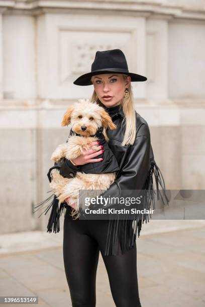 Lexi Fargo wears a Zara jacket, Intimissimi leggings, Hermes hat and Chanel earrings with Duke the dog wearing Prada during London Fashion Week...