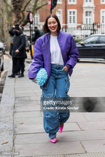 Tiffany Hsu wears The Attico jeans, Remain jacket, white t shirt, Bottega Veneta bag and Balenciaga shoes during London Fashion Week February 2022 on...